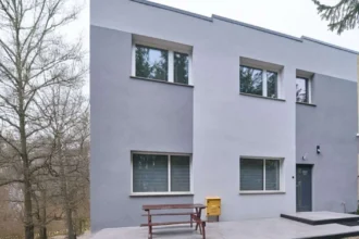 Tanie noclegi w Płocku - budynek hotelu z widocznym wejściem i miejscami parkingowymi